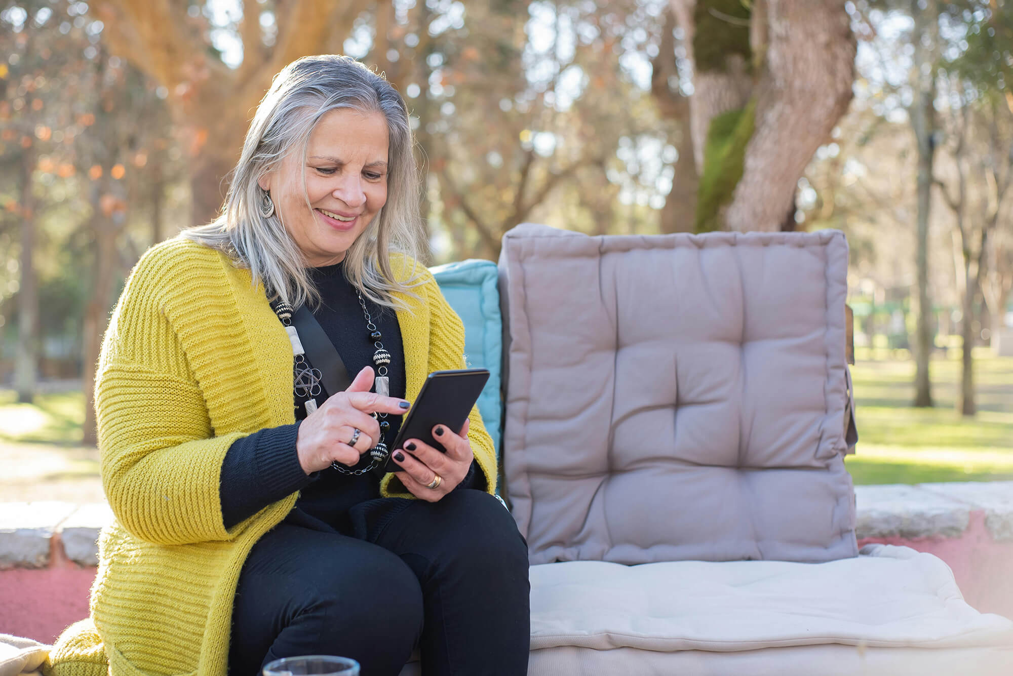 Adult sitting outside while on a phone.