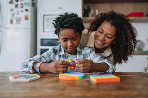 Child and adult playing with a fidget spinner.