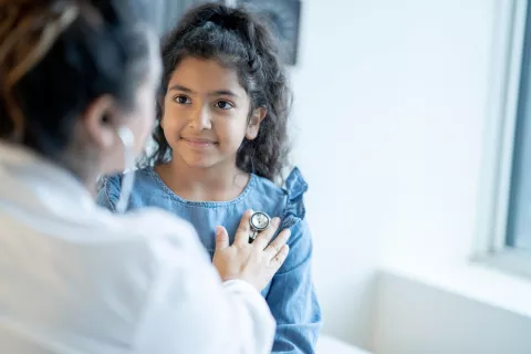 Doctor using stethoscope on a young child.