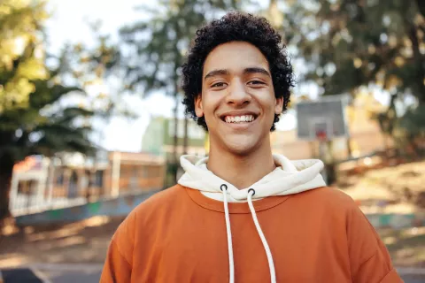 a headshot of a smiling young adult at an outdoor park