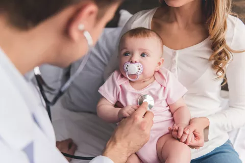 Doctor using stethoscope on a baby.