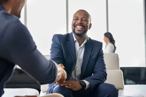 Adult shaking hands with another person.