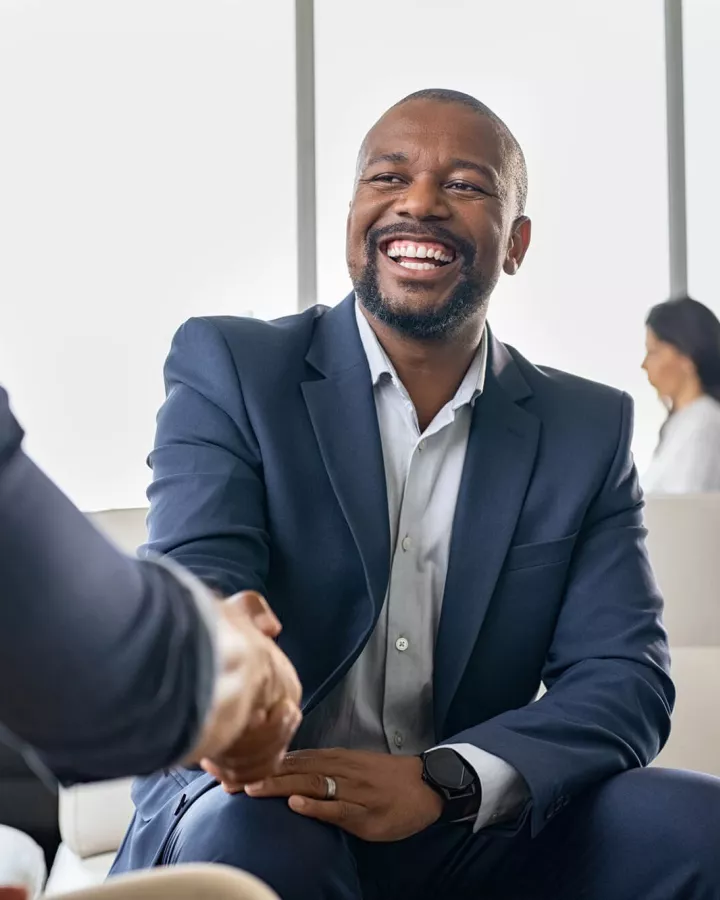 Adult shaking hands with another person.