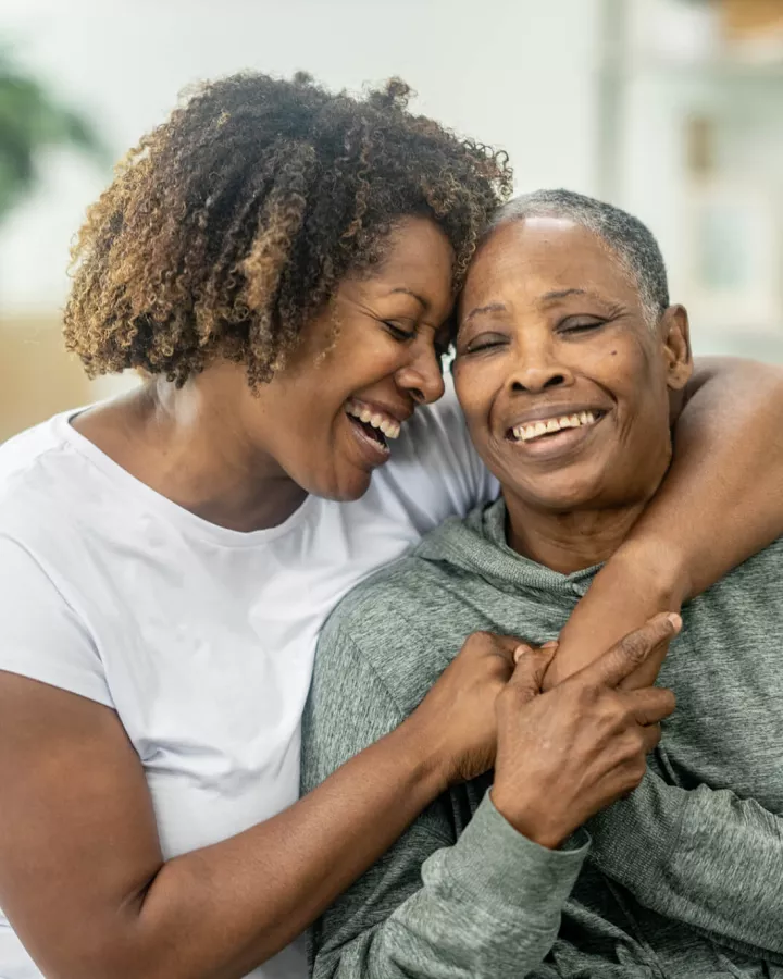 An adult and senior adult embracing each other