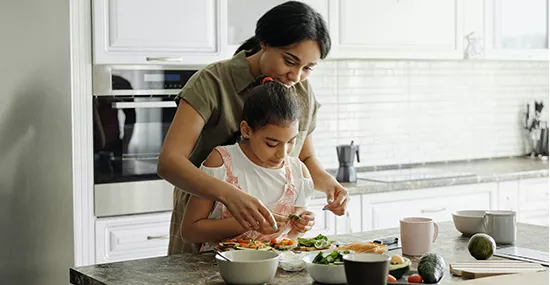 Madre e hija cocinando adentro