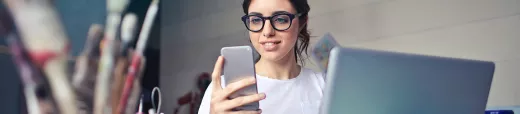una joven usando el teléfono y la computadora